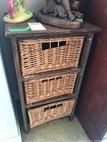 Front view of wood shelf with three wicker baskets, showing condition and storage design