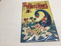 Full cover of The Flintstones and Pebbles comic book No. 1 inside a plastic protective sleeve on a white surface.
