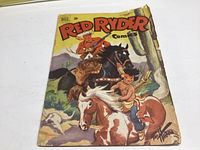 Front cover of Red Ryder comic book showing cowboy, horses, and desert scene with cactus, with visible wear and creases.