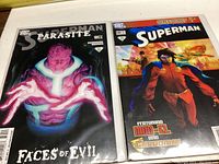 Photo showing Superman Parasite Faces of Evil #12 comic and Superman World Without Superman #87 comic next to each other.