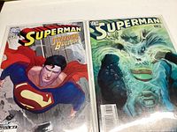 Photo showing two Superman comics: Superman Speeding Bullet #1 with Superman flying forward and another Superman comic with a green underwater-themed cover