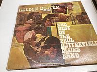Front view of album cover for 'The Best of the Paul Butterfield Blues Band' showing collage style band photos and title text in yellow and brown tones.