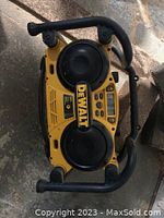 Top view of DeWalt construction radio showing dual front speakers, display, and control buttons.