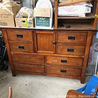 Front view of wooden dresser with four small drawers, one central cabinet, and three larger drawers below. Missing 2 drawer pulls.