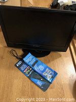 Full view of Dynex TV with a packaged HD antenna in front.