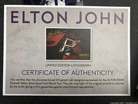 Close-up of certificate of authenticity for Elton John Farewell Yellow Brick Road limited edition lithograph, confirming original artwork and exclusive design for the final world tour.
