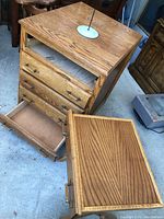 Full view showing open bottom drawer, wooden grain surface, and rollers.