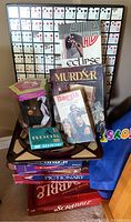 Board games including Eclipse, Murder mystery, Barnga card game, Rook card decks, Furby electronic toy, and Jeopardy game on a chair.