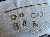 Flexible textured gold chain bracelet with box clasp on white towel