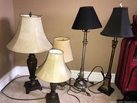 Five table lamps arranged side by side showing varying heights, base styles, and fabric shades.