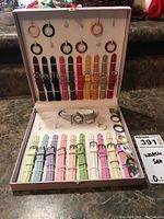 Full set of My Wish watch with 10 bands hanging and laying flat, 12 faceplates, and one assembled watch in open box