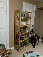 Full view of wood shelf against wall with various items placed on shelves.