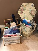 Two knitting bags filled with yarn balls, knitting hooks, and knitting books, plus a floral hexagonal hat box storing ribbon and trim supplies.