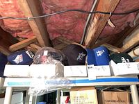Wide photo showing five MLB baseball caps in labeled boxes