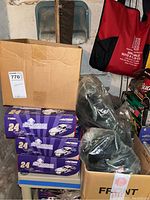Four boxed Jeff Gordon 1:24 scale diecast cars stacked next to boxes and bags.