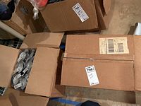 Two cardboard boxes, partially open, showing several travel mugs inside.