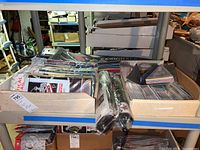 Shelf with assorted NFL vertical flags, pennants, and banners, packaged and rolled, with visible team branding and colors.