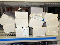Several closed plain white boxes on a metal shelf containing the car flags.