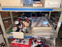 Photo shows shelf with NFL football player plush dolls and packaged NCAA window clings.