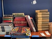Shelf with various vintage books including multicolor hardcovers and a set of encyclopedias or reference books.