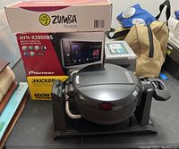 Overview photo showing Pioneer AVH-X2800BS stereo packaging, Garmin GPS box, Black & Decker waffle maker, and Zumba Fitness set box.