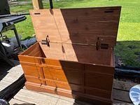 Open cedar wooden storage chest showing interior and metal hinges