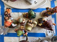Overhead view of eight Goebel Hummel figurines showing various children and poses.