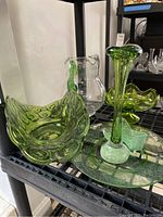 Overview of green glassware including candy dish, shoe, pitcher and serving dish