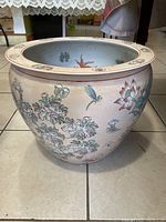 Side view showing overall shape and floral design on outside of large ceramic planter.