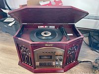 Front angle showing the wooden cabinet turntable stereo unit with record player and cassette deck visible.