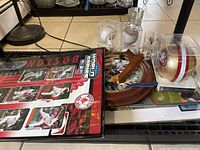 Framed Boston Red Sox 2004 World Series champion poster showing player action shots and logos, with partial view of other items on shelf.