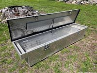 Open view of aluminum diamond plate storage box showing interior and lid with struts.