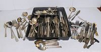 Overall view of silverplate lot showing various flatware pieces and black organizer tray