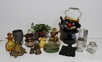 Front view of mixed vintage collectible items including figurines, bells, soap dish, and clown teapot