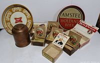 Vintage tobacco and beer memorabilia lot showing wooden cigar boxes, humidor, copper container, and two metal beer trays.