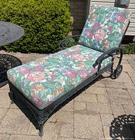 Overview of adjustable chaise lounge with floral cushion on stone patio