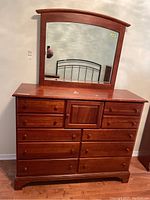 View of twelve-drawer Victorian style dresser with large attached curved-top mirror showing overall condition and finish.