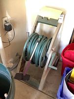 Full view of Ames hose reel with garden hose and cleaning brush attached