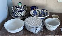 Photo showing all items including covered platter, various bowls including floral and plain styles, and casserole with lid