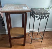 Two small tables shown together against wall on hardwood floor, wood and ceramic table on left, metal and stone table on right.