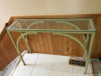 Full view of the metal base and glass top hall table showing overall structure and condition.