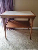 Front full view of the teak side table with faux marble top and lower shelf, showing overall design and condition.