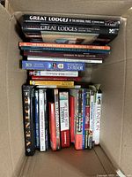 Books in a box showing a variety of hardcover and paperback titles, mostly about travel, history, and photography.
