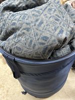Close-up of the storage container holding the comforter, showing fabric material and zipper.