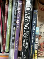 Photo shows the spines of several crafting books including woodcarving, knitting, philosophy, and a peer geek handbook.