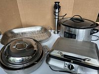 The lot overview showing All-Clad grill pan with rack and lid, Cuisinart immersion blender, Crockpot slow cooker, and Cuisinart waffle maker.