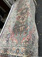 Photo capturing angled view of the oriental rug showing detailed pattern and condition.
