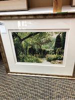 Full view of framed print showing pathway through lush garden with frame and matting
