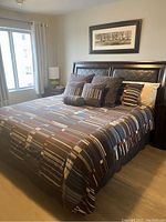 Full assembled king bed with bedding and pillows in room