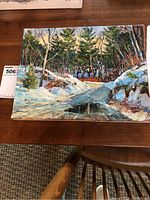 Full view of the oil painting showing a snowy forest landscape with trees and a creek or frozen path.